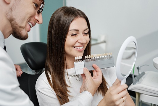 Dentist using shade guide on a patient