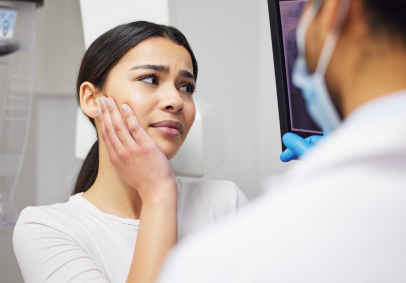 A woman suffering a common dental emergency